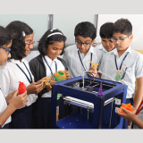 Students eagerly observing a 3D printing demonstration with excitement and curiosity