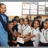 CHIREC students expressing gratitude with a 'Thank You' card to the helping staff.